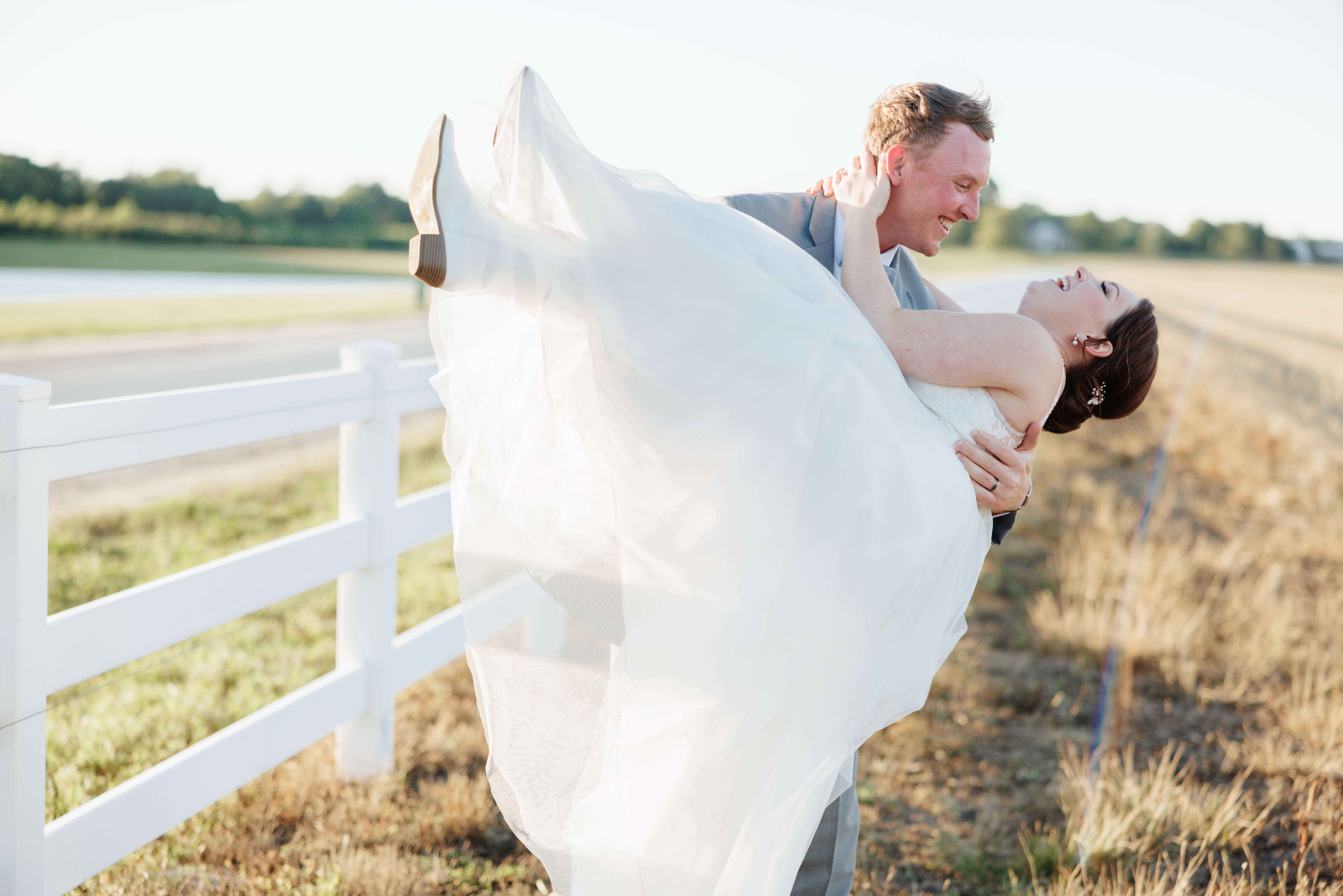 Malden Hill Spring Wedding Photography 37 groom holding bride in a field