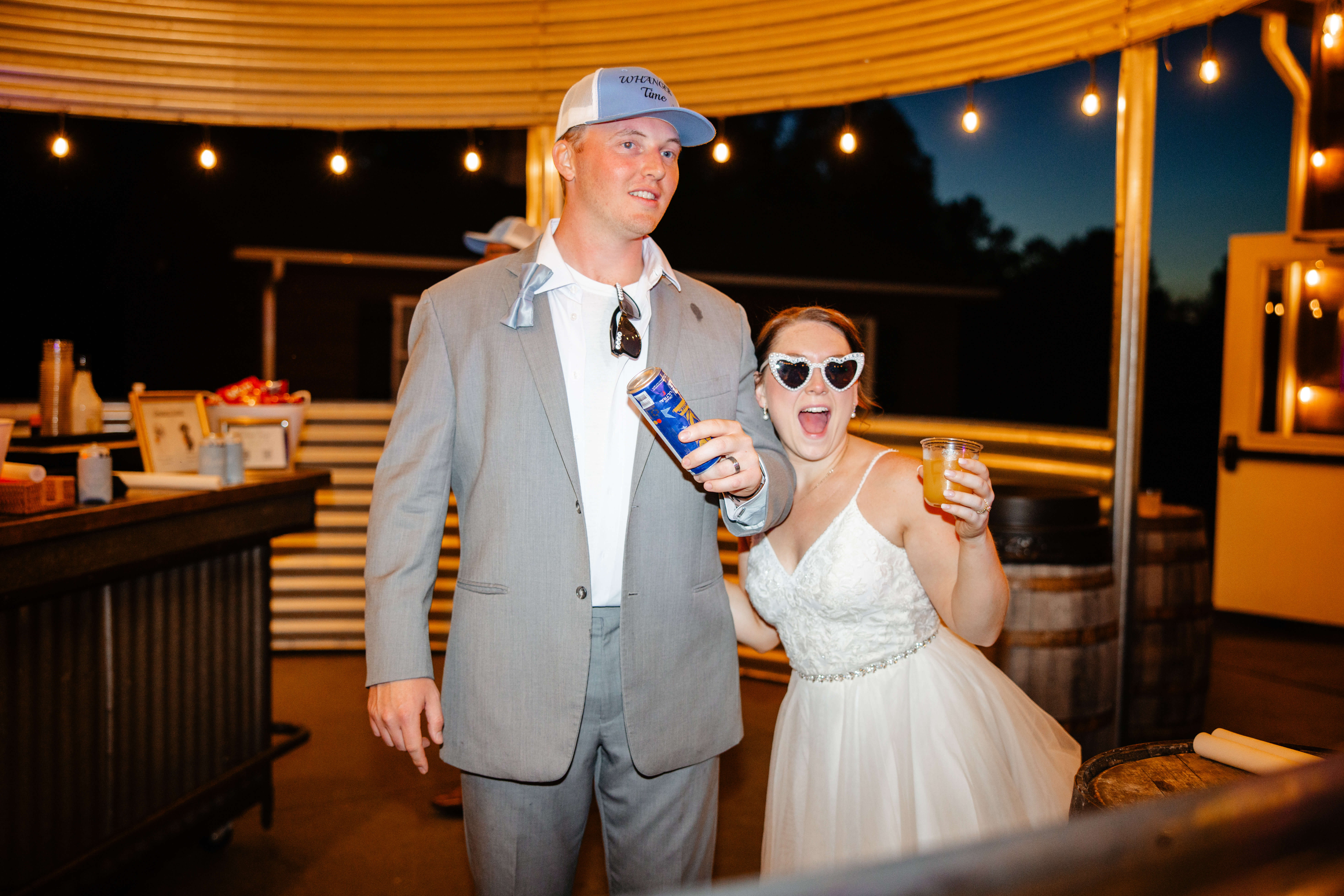 Malden Hill Spring Wedding Photography 44 bride and groom holding drinks and standing under in silo style patio