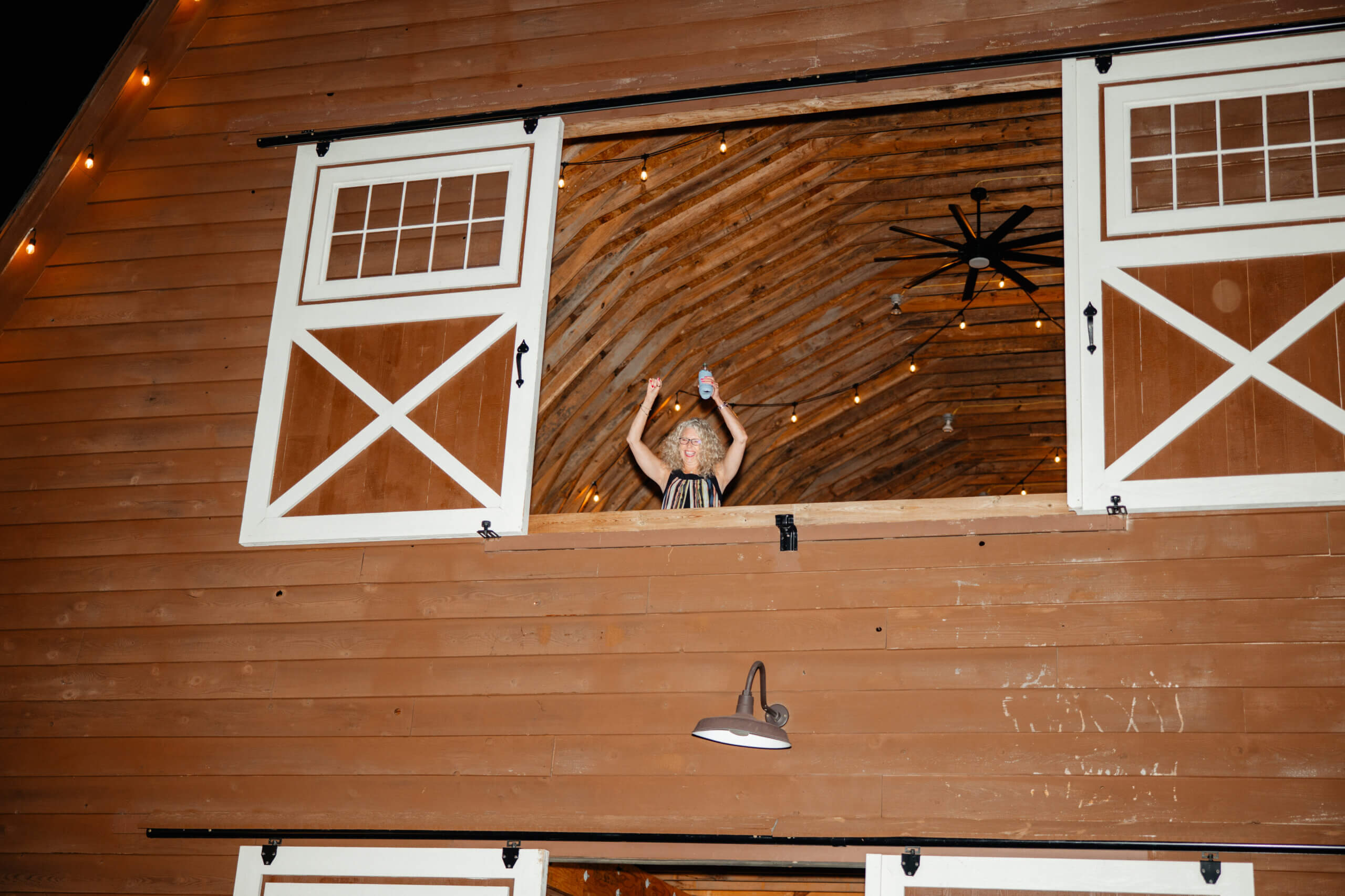 Malden Hill Spring Wedding Photography 47 guest standing and cheering in the upstairs window of the barn