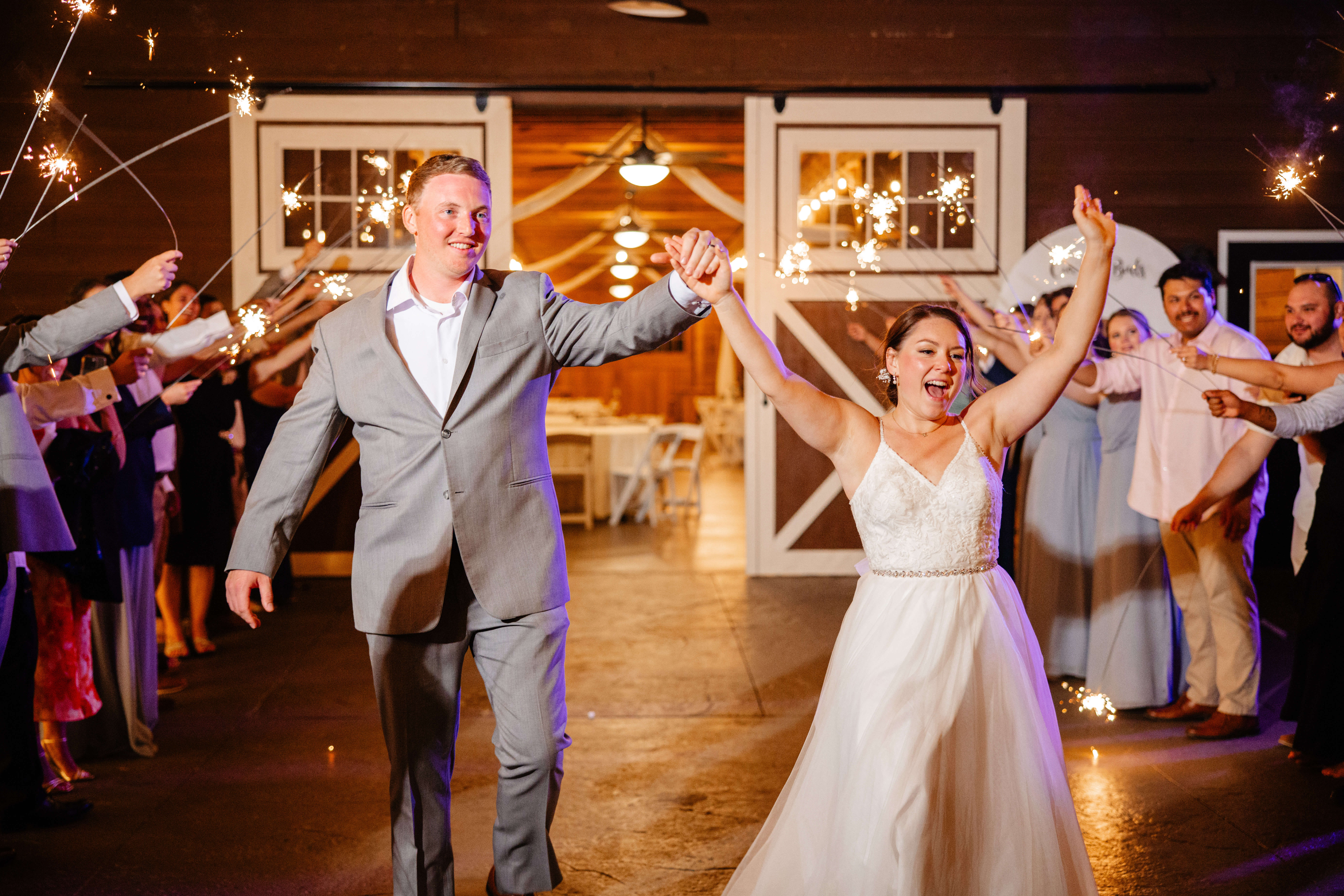 Malden Hill Spring Wedding Photography 48 bride and groom holding hands and exiting the reception with their guests standing around them