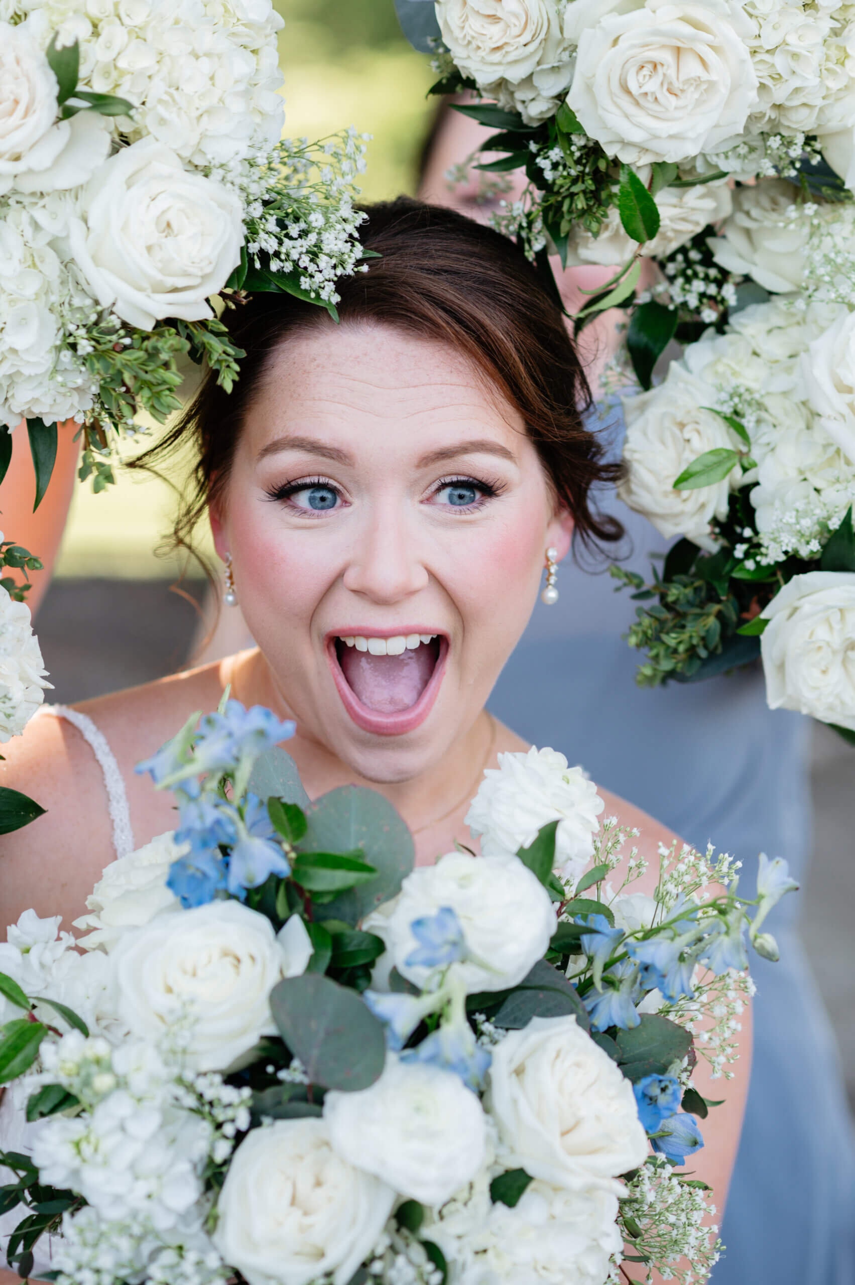 Malden Hill Spring Wedding Photography 13 bride smiling with bridesmaids bouquets surrounding her face