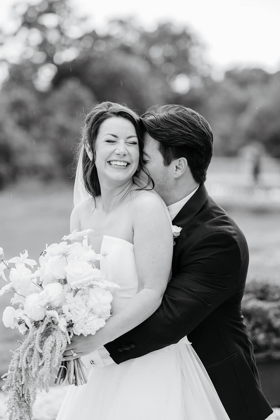 Estate at River Run Summer Wedding Photography 23 groom and white photo of groom hugging bride from behind, his face is tucked into her neck