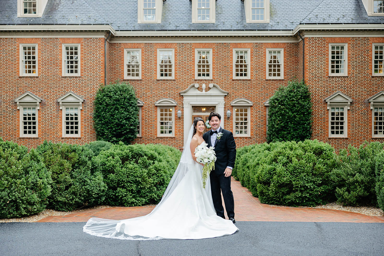 Estate at River Run Summer Wedding Photography 26 portrait of bride and groom standing outside large brick manor house