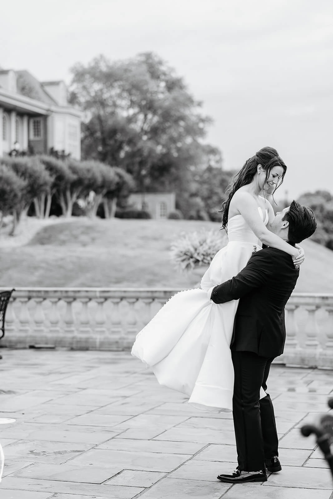 Estate at River Run Summer Wedding Photography 29 black and white photo. of groom lifting up bride and spinning her around
