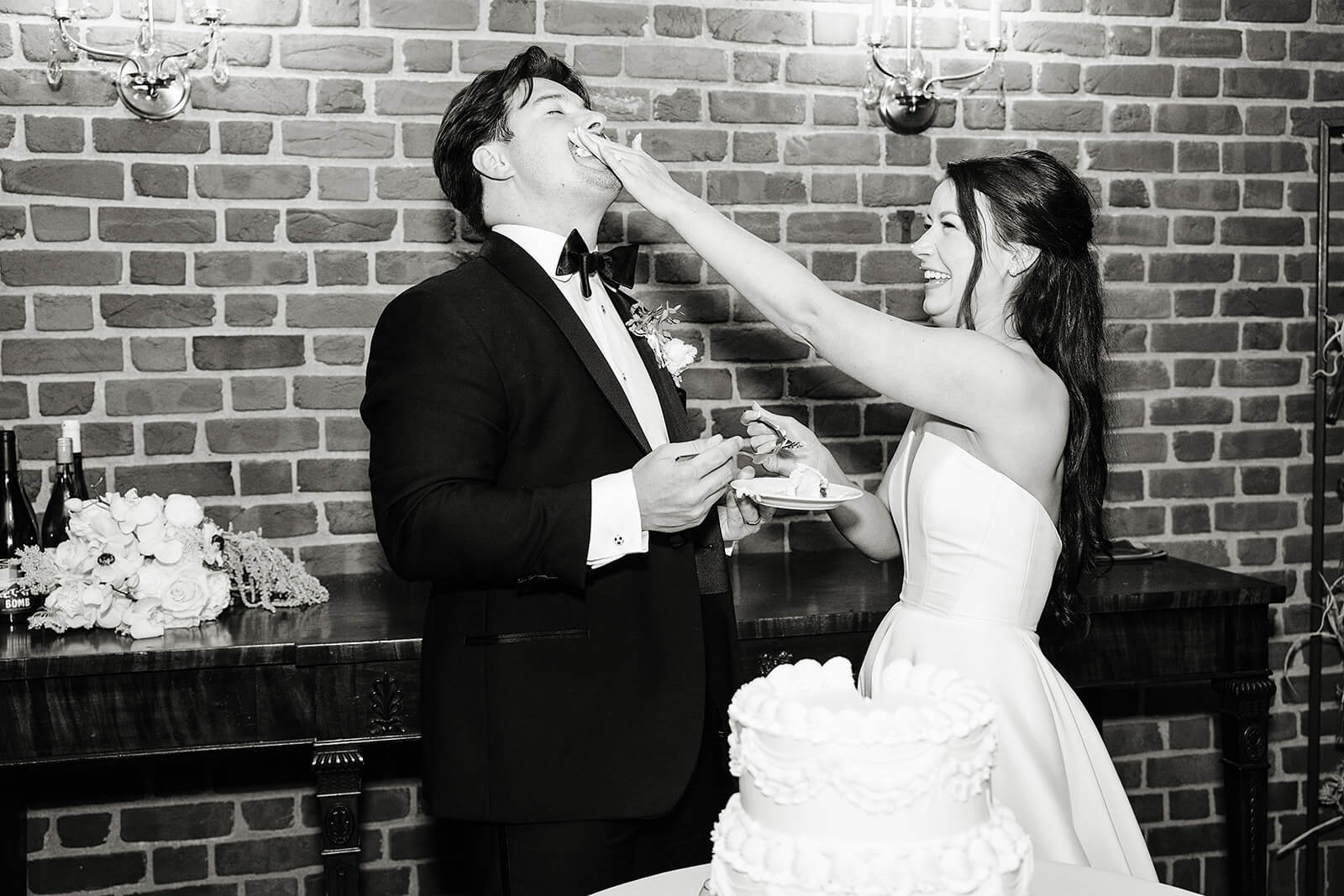 Estate at River Run Summer Wedding Photography 36 black and white photo of bride smearing grooms face with cake