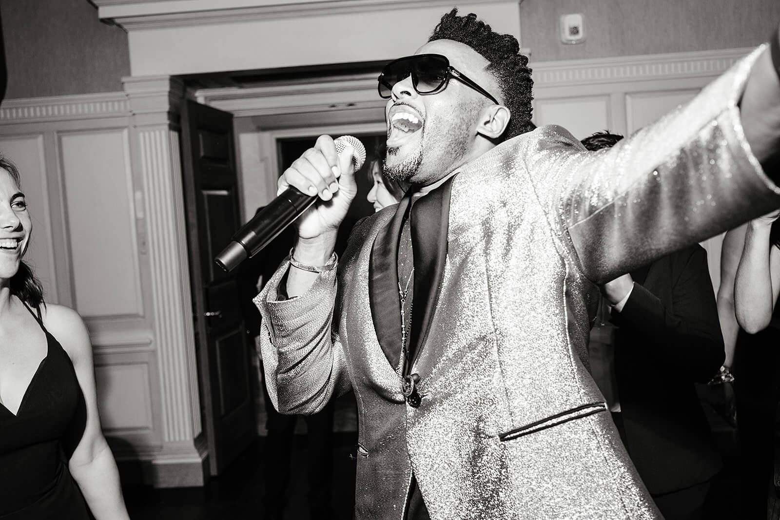 Estate at River Run Summer Wedding Photography 46 black and white photo of band singer singing among guests on the dance floor