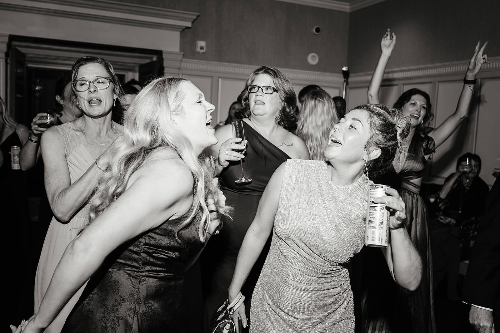 Estate at River Run Summer Wedding Photography 47 black and white photo of women holding drinks as they dance and jump together