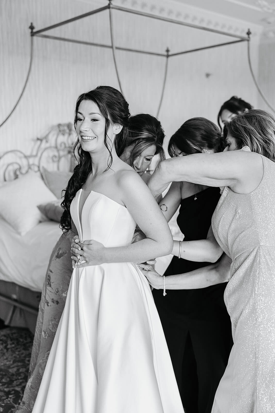 Estate at River Run Summer Wedding Photography 9 black and white photo of bride in her dress with all her bridesmaids zipping her dress