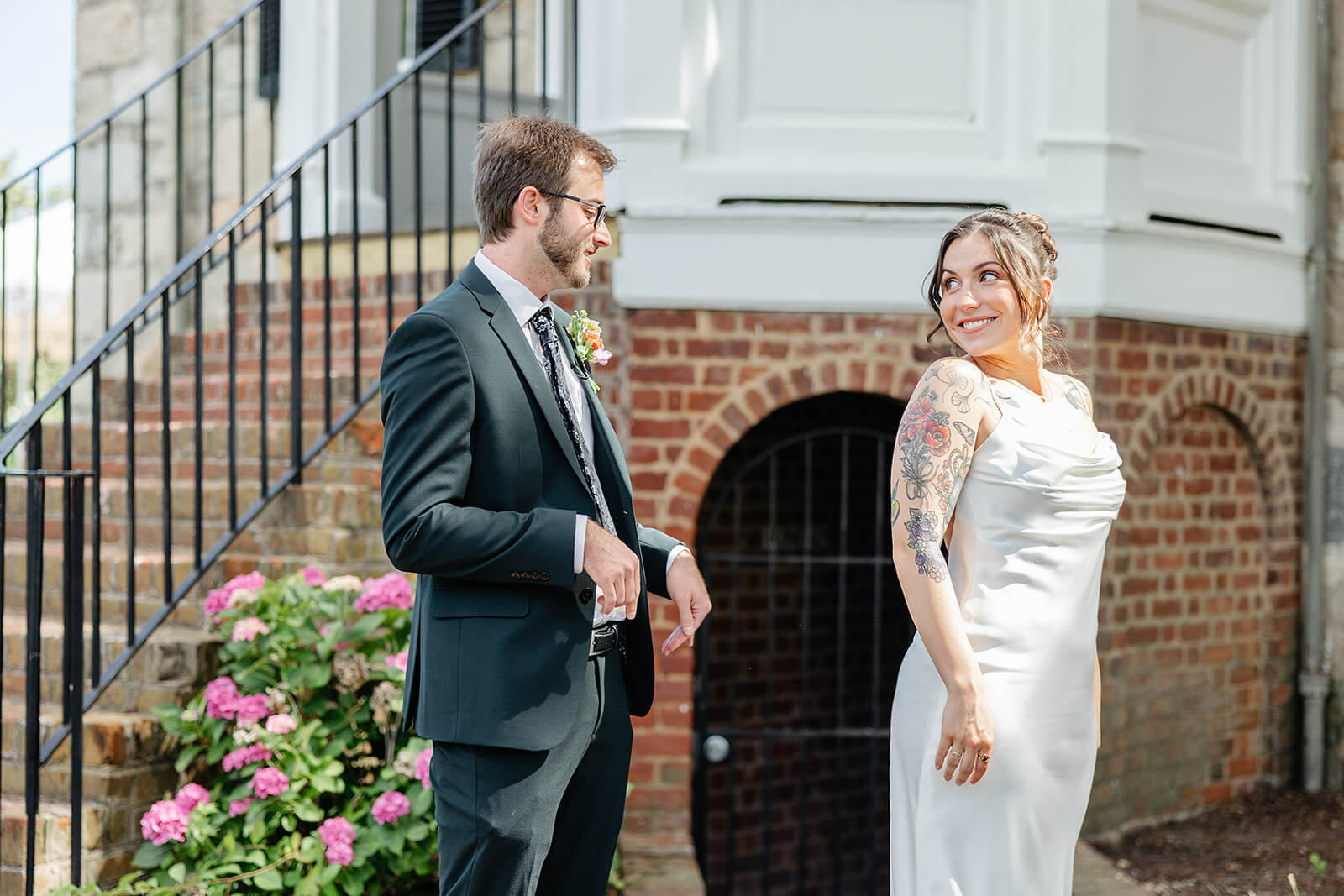 Laura Lee's Spring Wedding Photography 4 bride showing groom her dress, she is facing away from him and looking over her shoulder to see his expression
