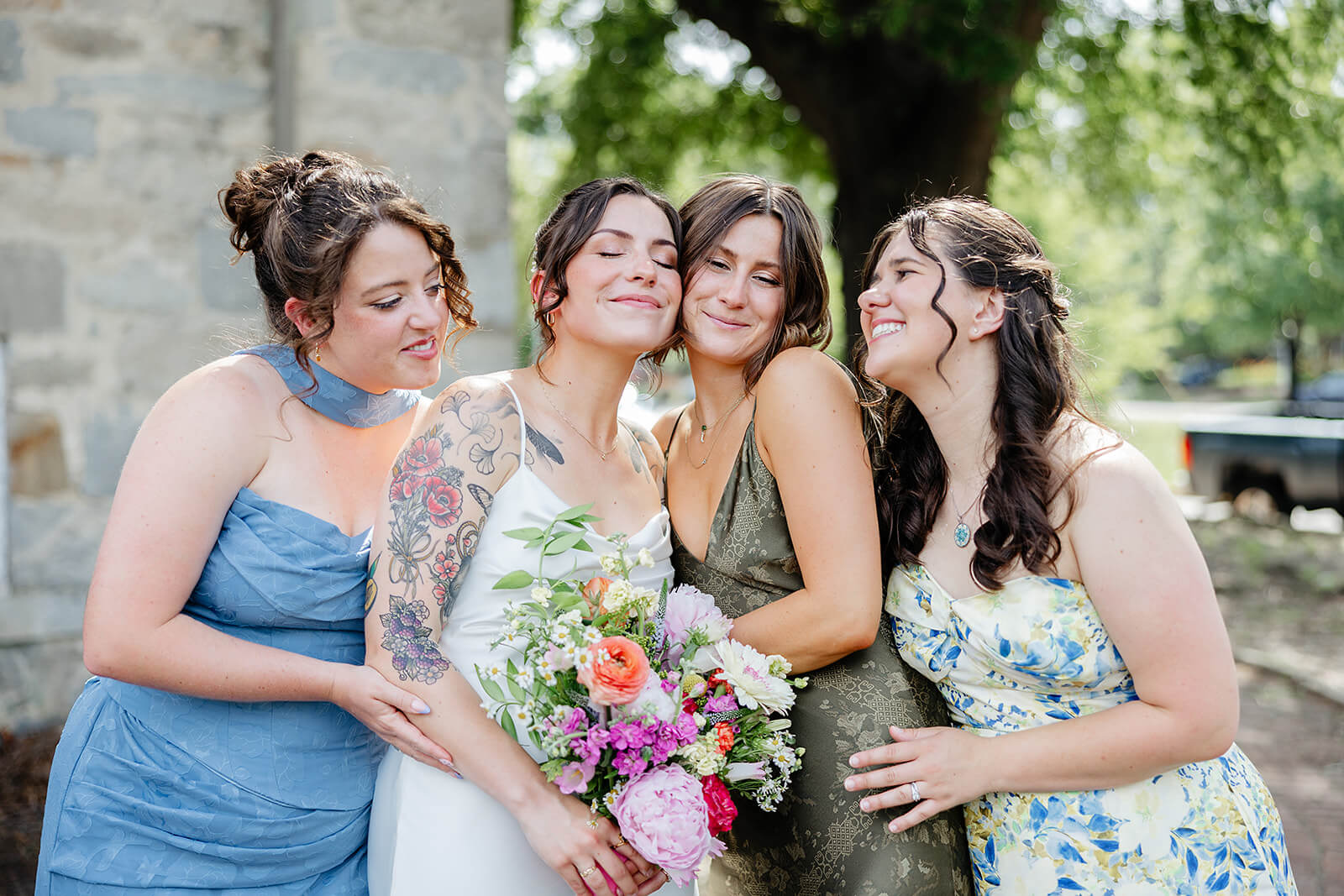 Laura Lee's Spring Wedding Photography 6 bride holding multi color boquet being hugged by three friends in blue and green dresses