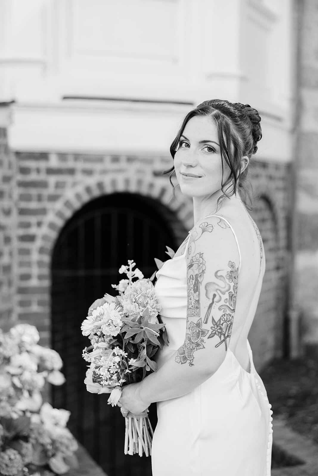 Laura Lee's Spring Wedding Photography 8 black and white photo of bride in dress holding her bouquet, you can see the backless dress