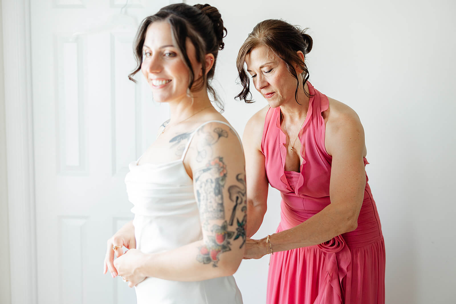 Laura Lee's Spring Wedding Photography 1 mom in pink dress helping bride zip her dress