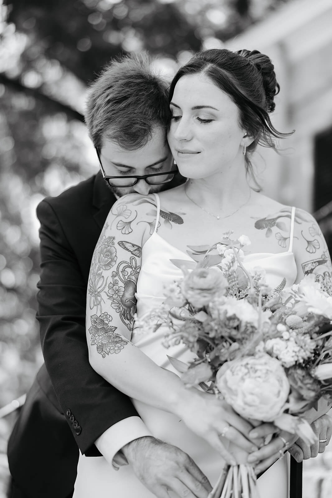 Laura Lee's Spring Wedding Photography 11 black and white photo of groom hugging bride from behind as she softly smiles at him