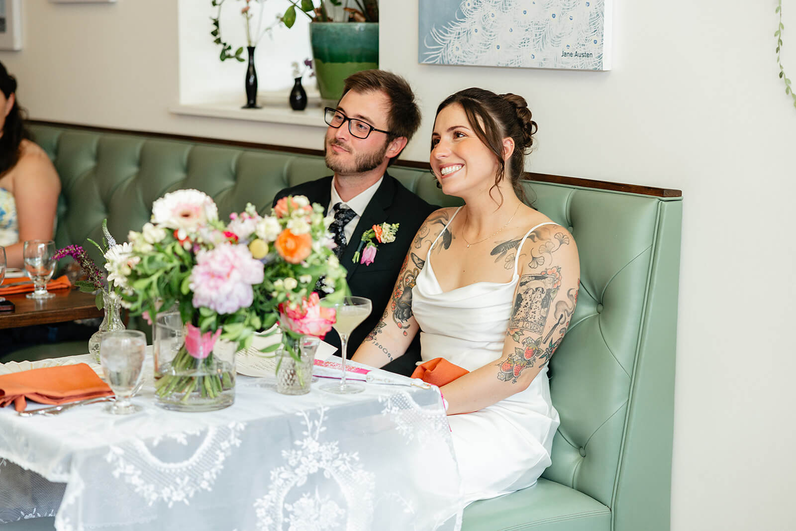 Laura Lee's Spring Wedding Photography 16 bride and groom smiling and holding hands as they listen to speeches