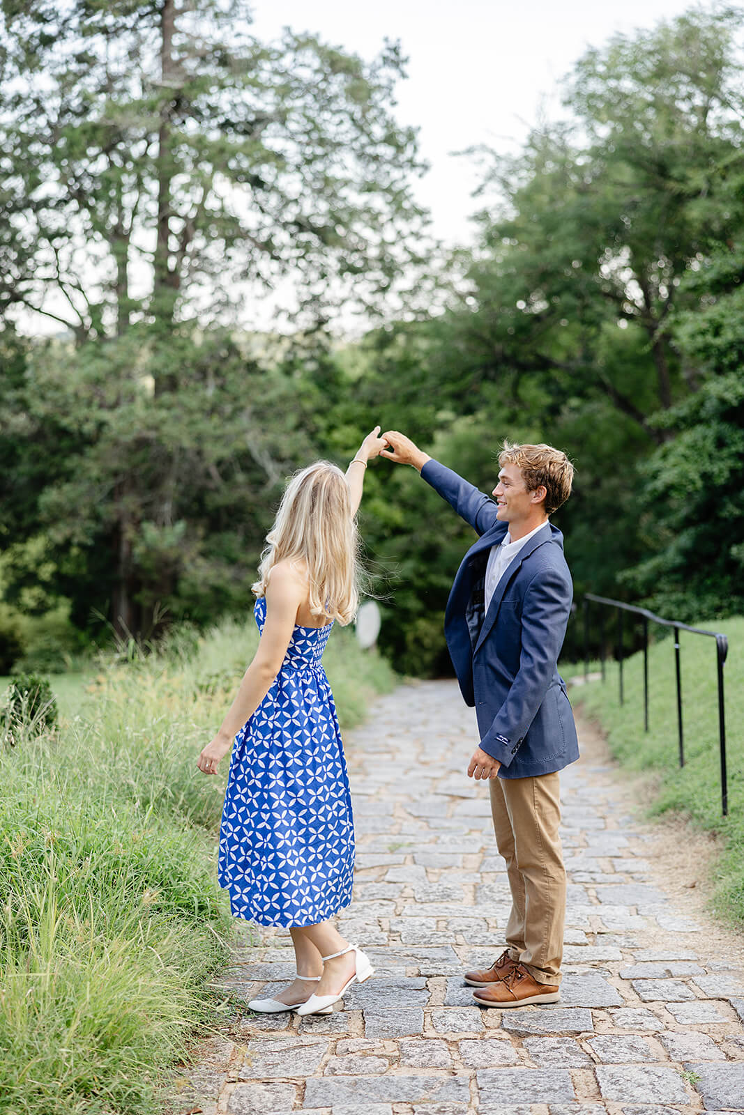 Maymont Summer Engagement Photography 8 man twirling fiance while standing on a stone path in a field
