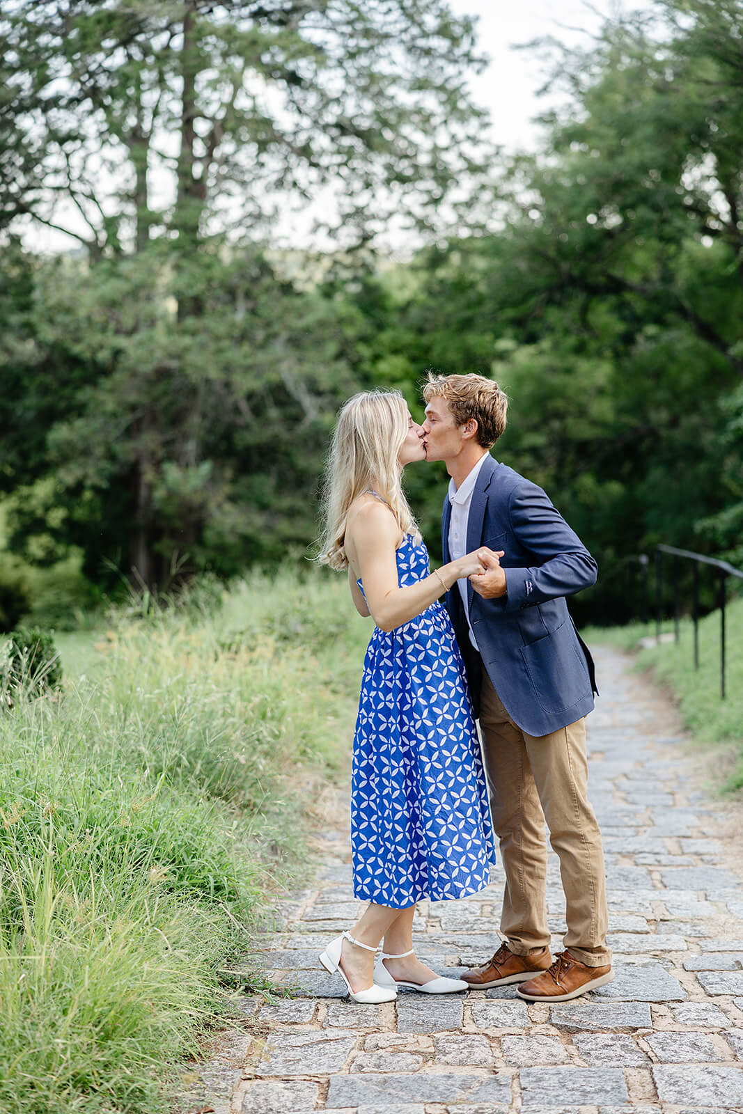 Maymont Summer Engagement Photography 9 couple kissing while standing on a stone path in a field