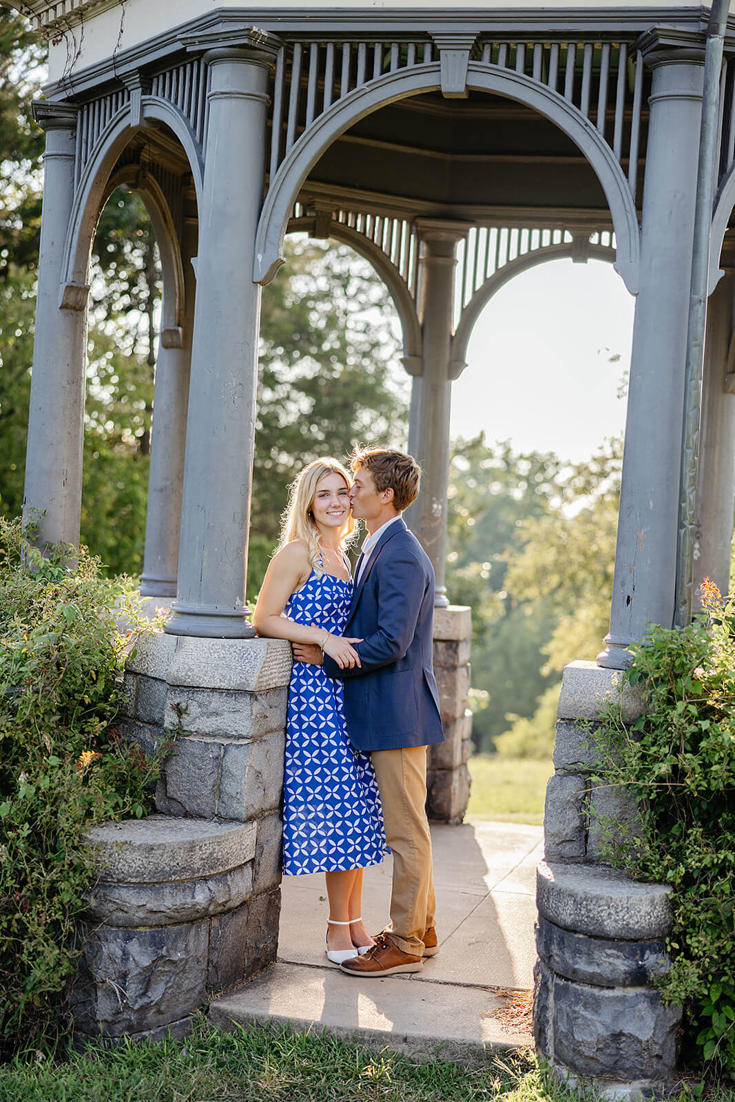 Maymont Summer Engagement Photography 11 man kissing his fiance's cheek while standing under a gazebo