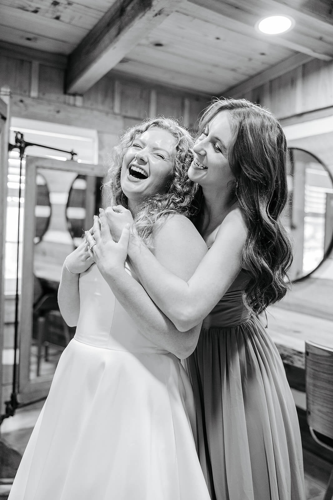 Rassawek Vineyard Spring Wedding Photography 7 black and white photo of bridesmaid hugging bride from behind