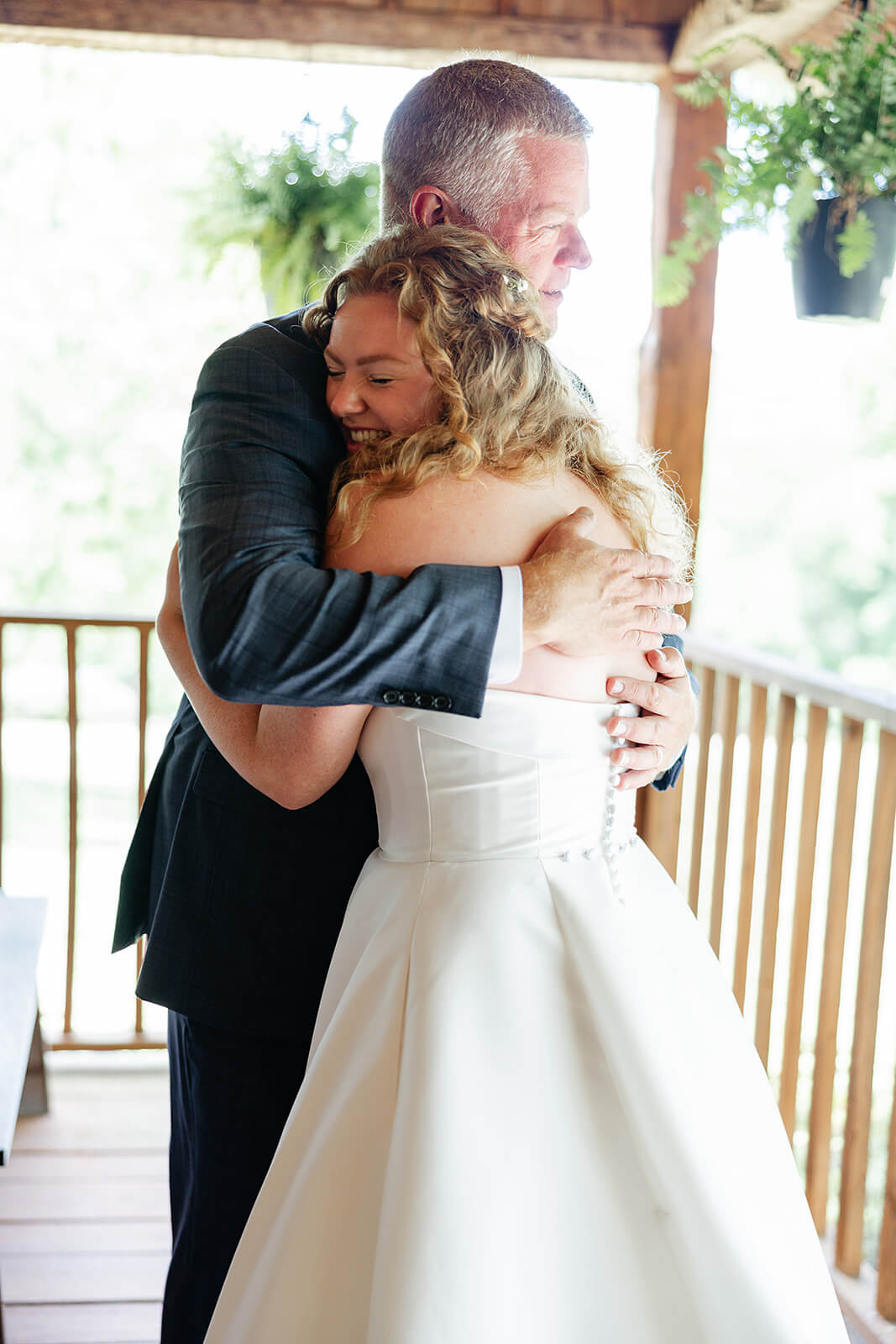 Rassawek Vineyard Spring Wedding Photography 8 bride hugging her dad on wooden porch outside