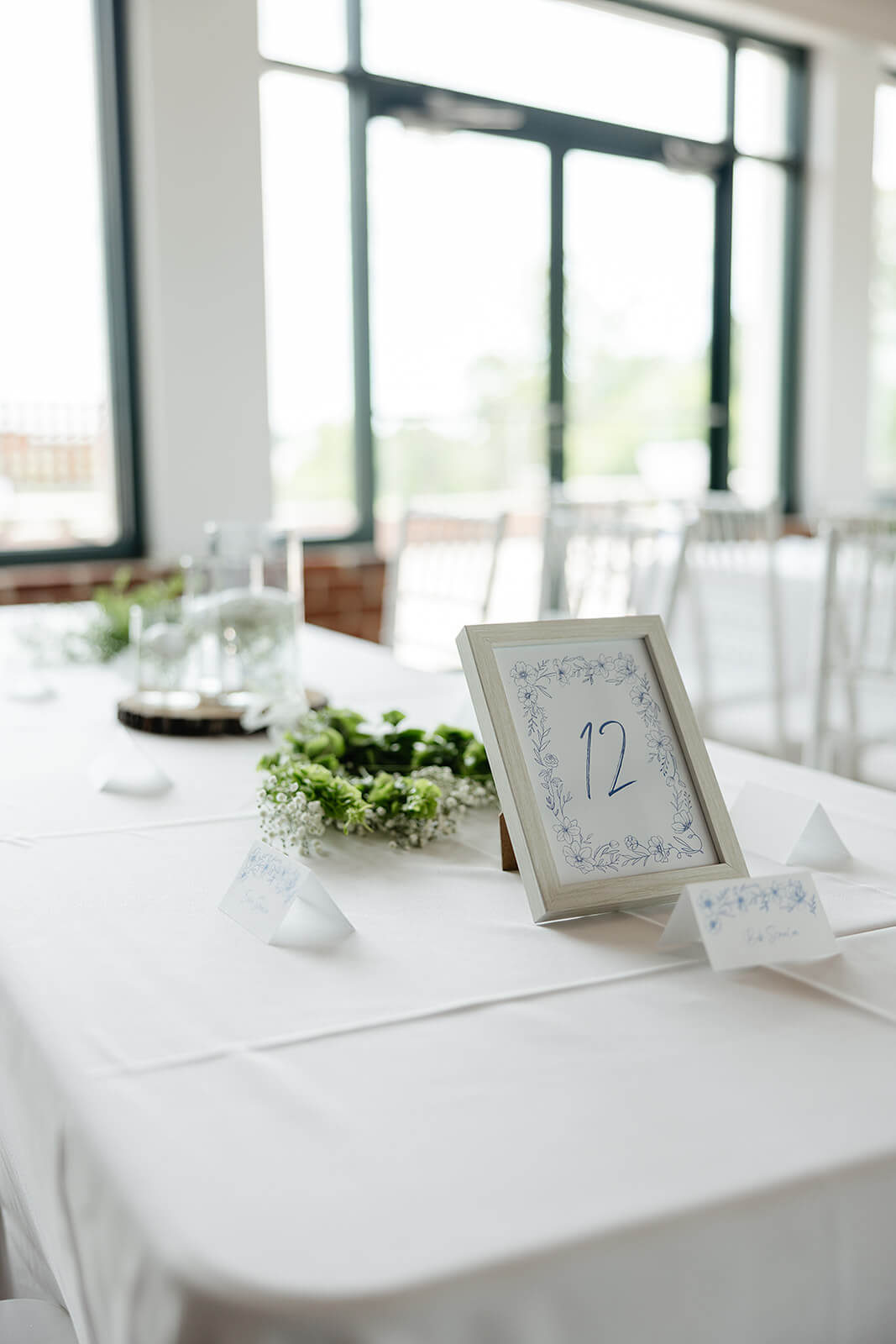 Rassawek Vineyard Spring Wedding Photography 19 table number with white wooden frame and blue florals and numbers
