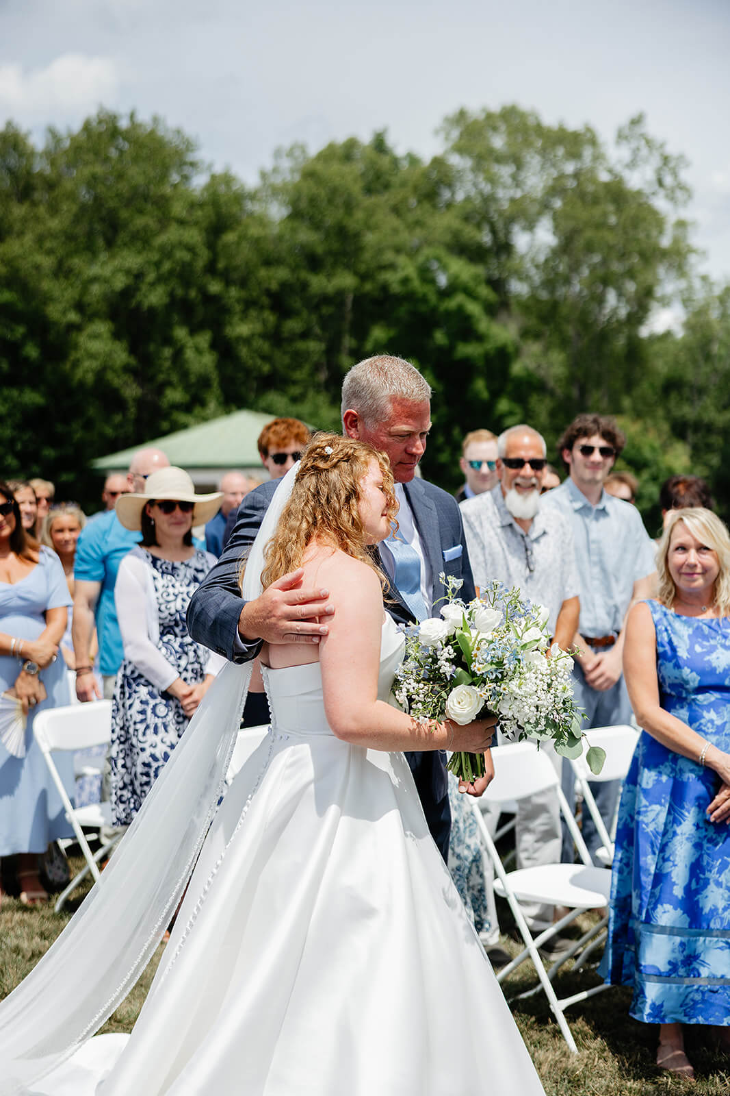 Rassawek Vineyard Spring Wedding Photography 14 bride hugging her dad at the end of the aisle with all the guests watching