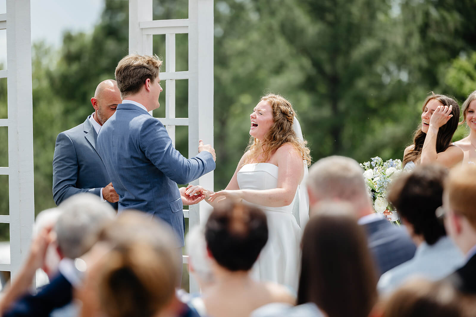 Rassawek Vineyard Spring Wedding Photography 15 bride laughing at the alter as she holds her husbands hands