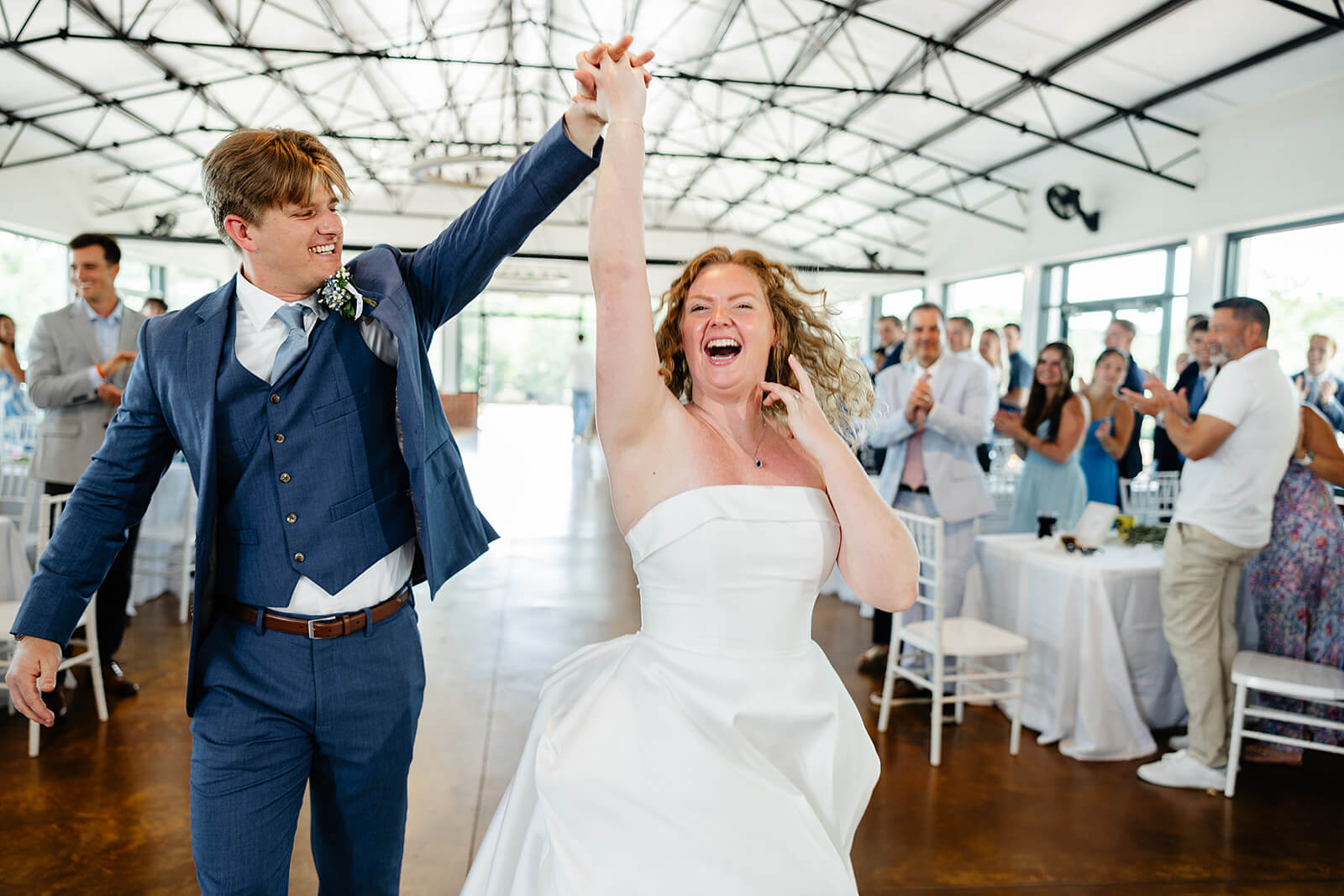 Rassawek Vineyard Spring Wedding Photography 34 bride and groom laughing as they hold hands and come into reception