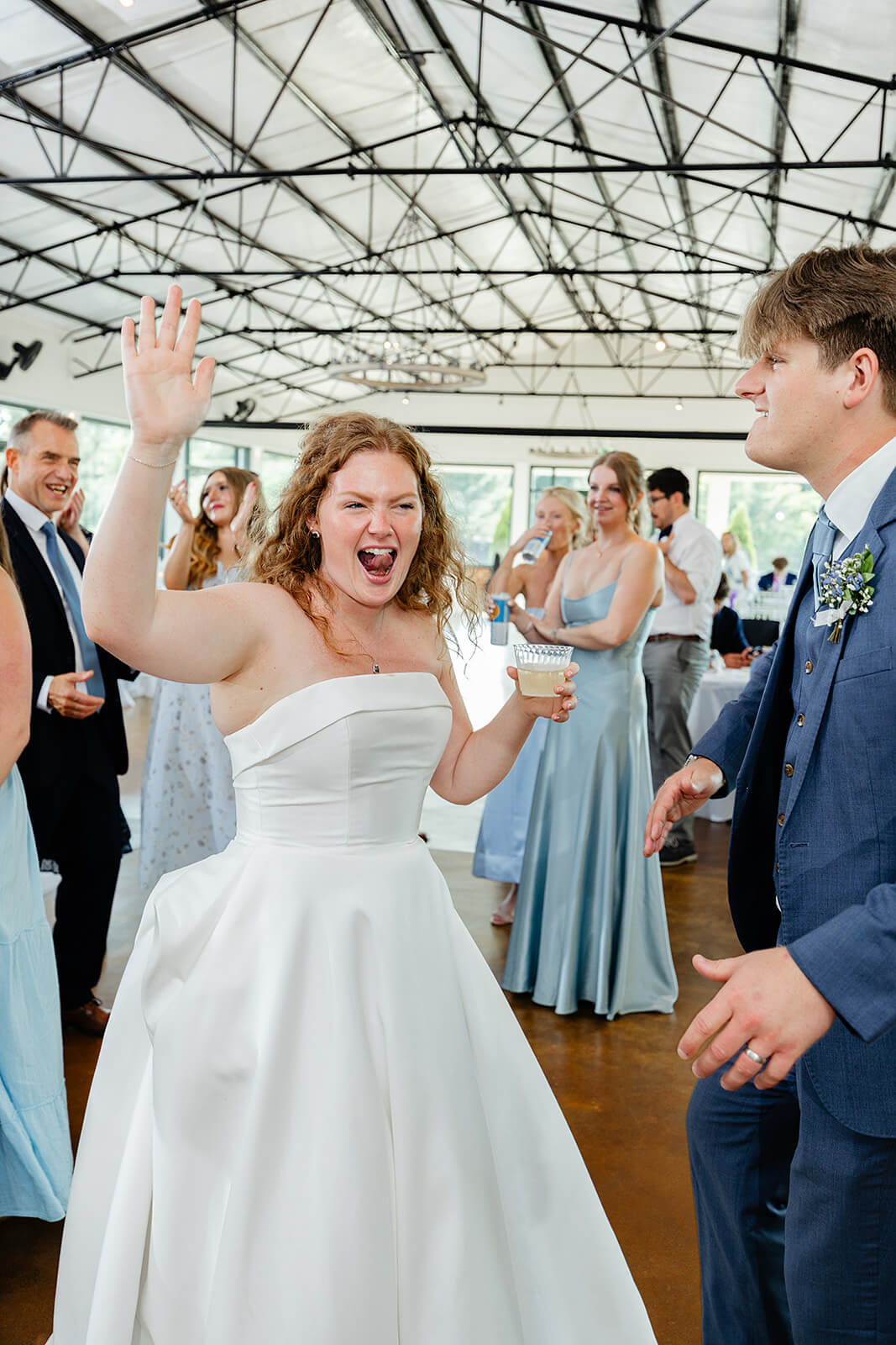 Rassawek Vineyard Spring Wedding Photography 37 bride and groom holding a drink and dancing with guests