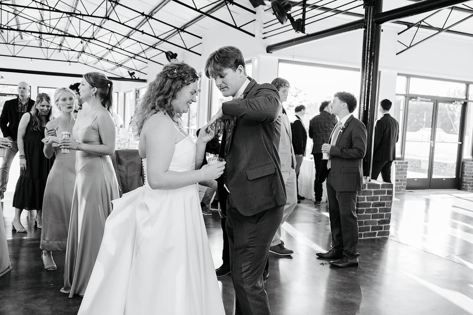 Rassawek Vineyard Spring Wedding Photography 38 black and white photo of bride looking at grooms wedding ring on the dance floor