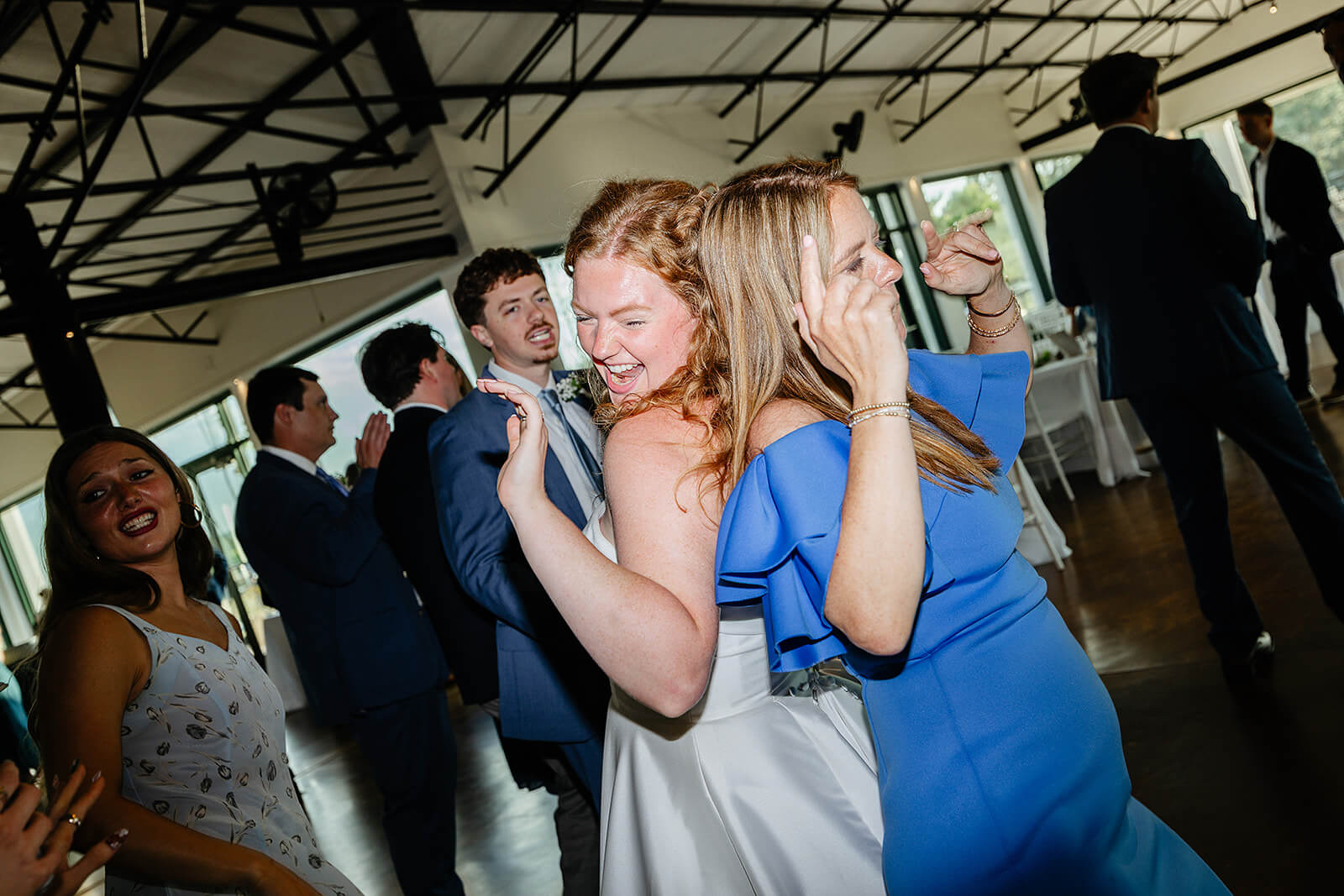 Rassawek Vineyard Spring Wedding Photography 40 bride dancing with guest, standing back to back
