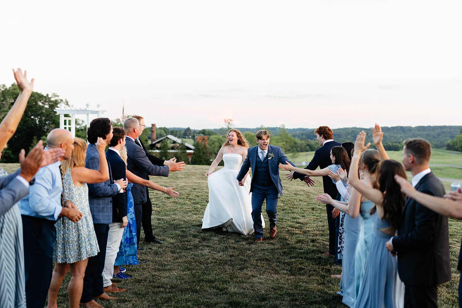 Rassawek Vineyard Spring Wedding Photography 45 guests lined up outside as the bride and groom run between the lines of guests