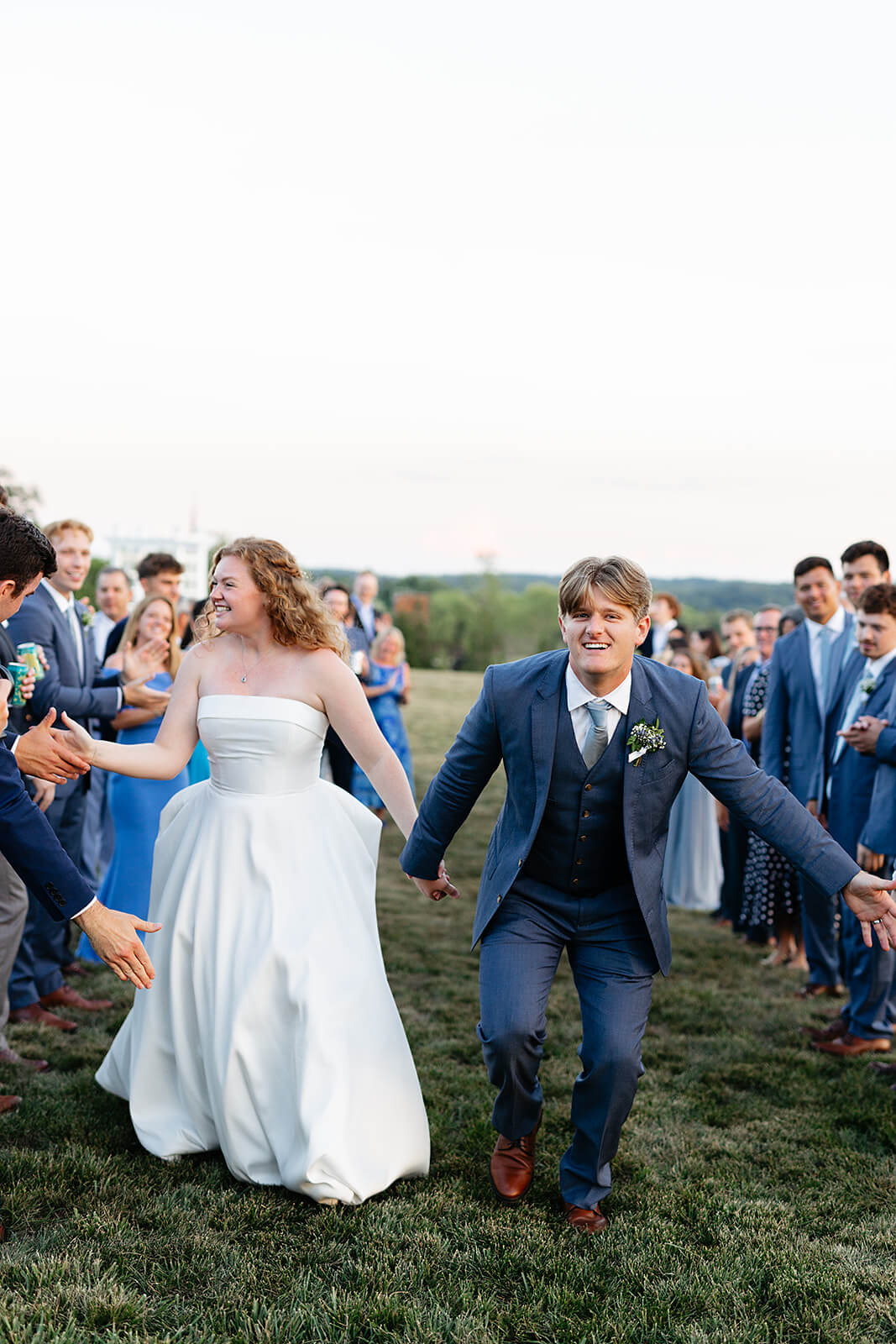 Rassawek Vineyard Spring Wedding Photography 46 bride and groom giving high fives to their cheering guests