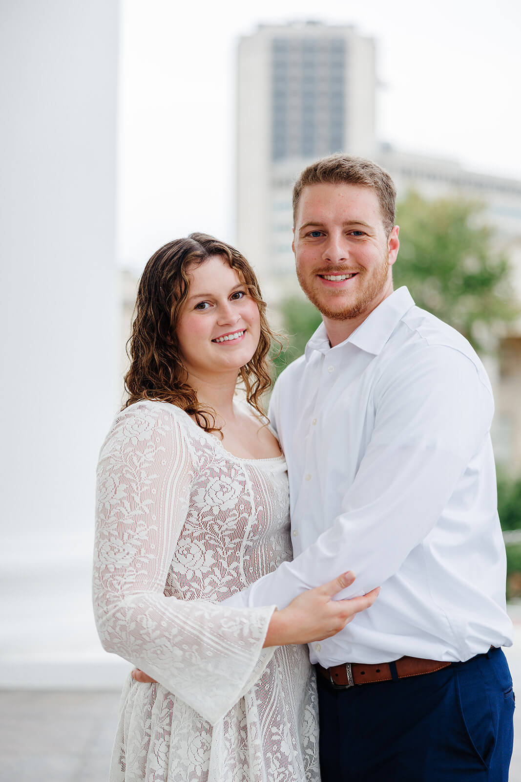 Virginia Capital Fall Engagement Photography 3 couple hugging each other outside on porch, she is wearing a flowy, white lace dress